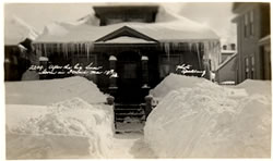 House and walkway covered in deep snow