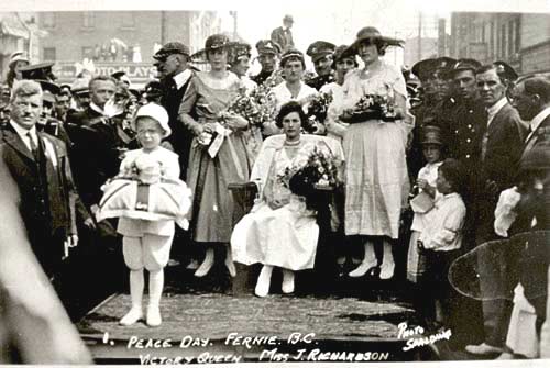 Group of women pose on a float surrounded by people in a parade
