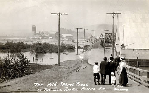 A family watches water flow over a bridge