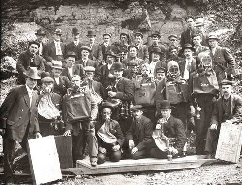 A group of men in mining clothes with mining gear