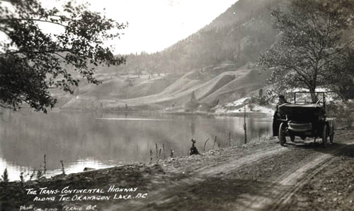 Car on a road along the shore of a lake